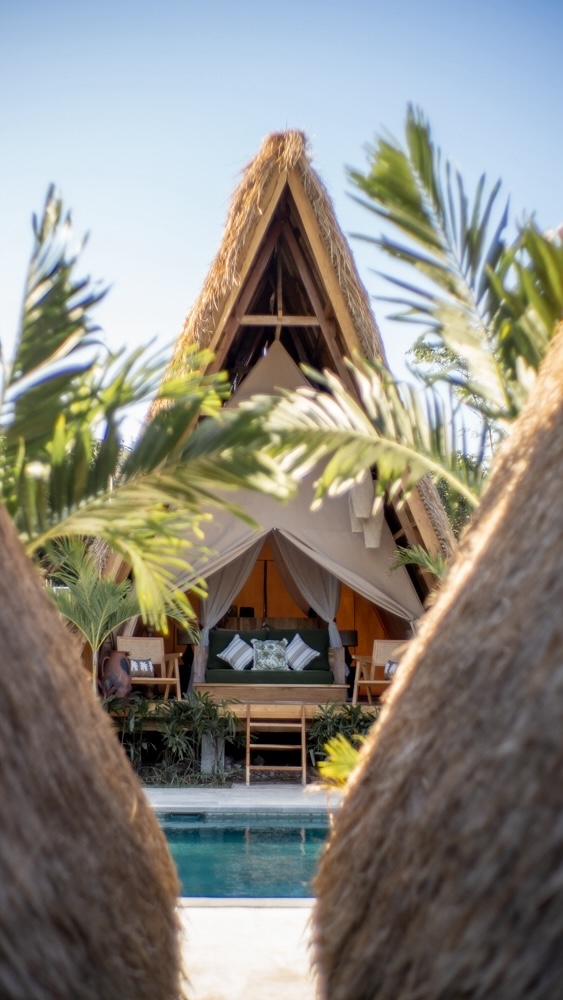 Glamping tent nestled in the greenery and overlooking the pool